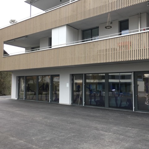 Eingang zum neuen Bodymotion Groupfitnessstudio. Die Parkplätze befinden sich direkt davor, der Veloständer rechts neben dem Gebäude.
